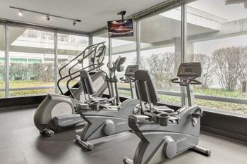 A gym with a treadmill and a stationary bike.